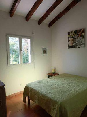 une chambre avec un lit et une fenêtre dans l'établissement MARCHESE, à Cargèse