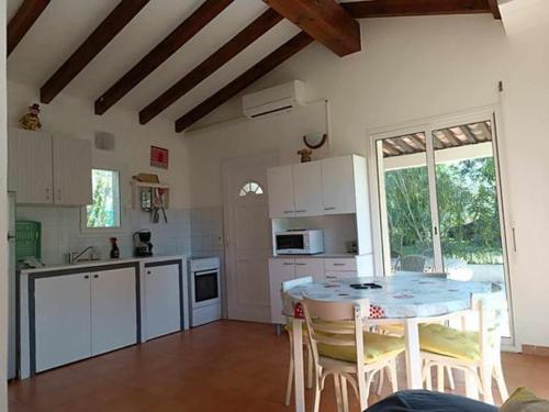 une cuisine avec une table et des chaises dans une pièce dans l'établissement MARCHESE, à Cargèse