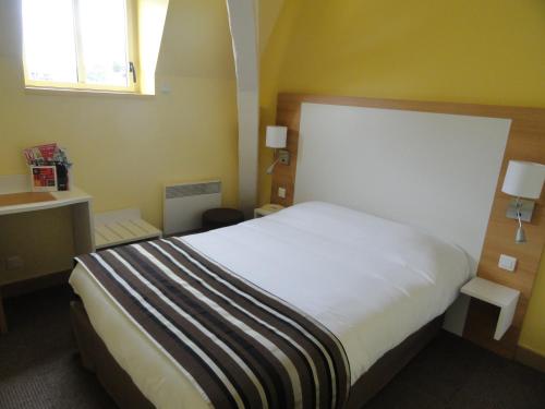 a bedroom with a white bed and a window at The Originals City, Hôtel Continental, Poitiers in Poitiers
