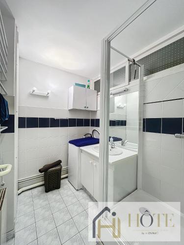 une salle de bain avec un lavabo et une douche dans l'établissement Le Marin - Vue Mer, à Bray-Dunes