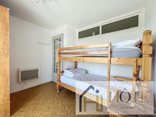 une chambre avec deux lits superposés dans une pièce dans l'établissement Le Marin - Vue Mer, à Bray-Dunes
