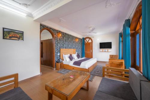 a hotel room with a bed and a table at Calm Cottage KASAULI HILLS Barog in Barog