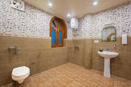 a bathroom with a toilet and a sink and a shower at Calm Cottage KASAULI HILLS Barog in Barog