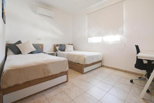- une chambre avec 2 lits et un bureau dans l'établissement Villa Argyro, à Ayia Napa