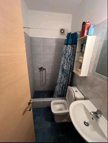 a bathroom with a shower and a toilet and a sink at Glifa Beach House Maisonette in Glida