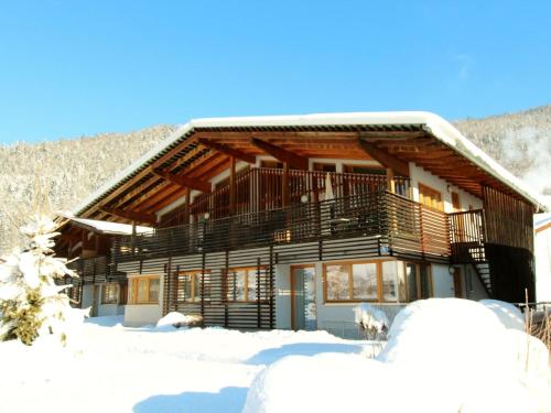 uma cabana de madeira na neve com neve em Modern Apartment in Kirchdorf with Garden em Kirchdorf in Tirol