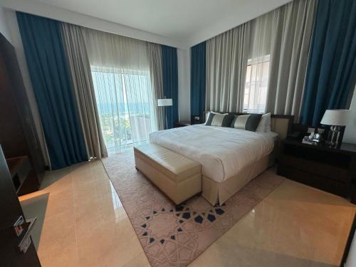a bedroom with a bed and a large window at 1 Bed Apartment-Rixos Fairmont Residences in Abu Dhabi