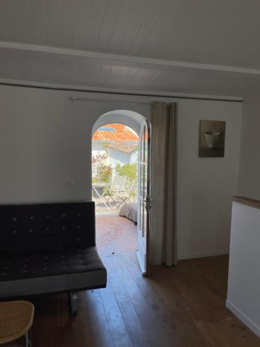 a living room with an open door to a patio at une fenêtre sur cour in La Flotte
