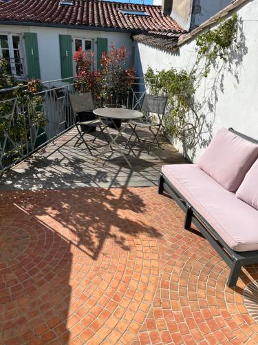 a patio with a couch and a table on a brick patio at une fenêtre sur cour in La Flotte