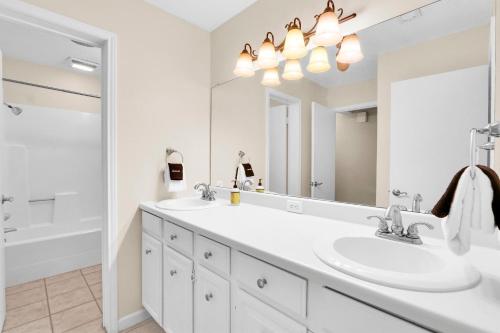 a white bathroom with two sinks and a large mirror at River Getaway in Fourth Crossing