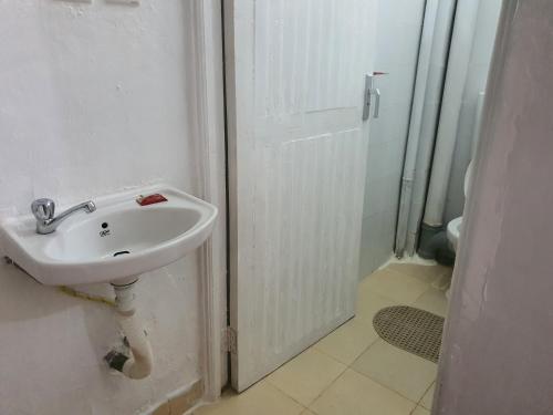 a white bathroom with a sink and a shower at Fahari1 in Meru