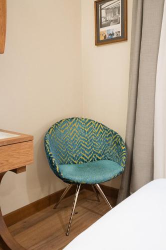 a chair sitting in a corner next to a desk at Duca D'Aosta Hotel in Aosta