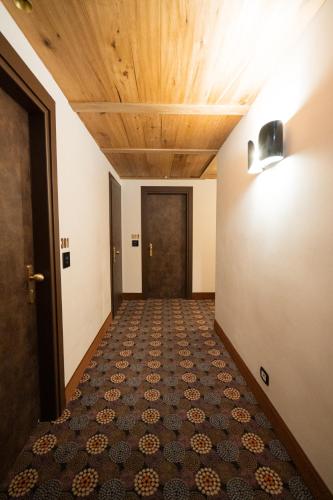 an empty corridor with a door and a tile floor at Duca D'Aosta Hotel in Aosta