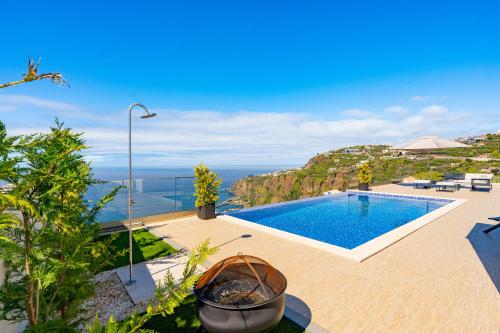 a villa with a pool and a view of the ocean at Lê Maison Deluxe Madeira in Ponta do Sol