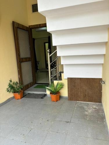 a building with two potted plants in front of a door at Dream Ashoka in Ujjain