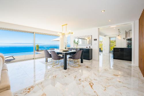 uma sala de jantar com uma mesa e vista para o oceano em Lê Maison Deluxe Madeira em Ponta do Sol