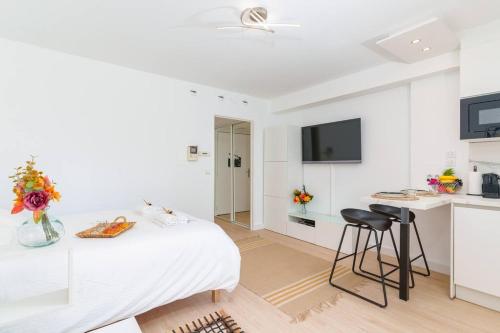 Cette chambre blanche dispose d'un lit, d'un bureau et d'une cuisine. dans l'établissement Le Bristol By ApiRent #Climatisation #Terrasse #Central, à Cannes