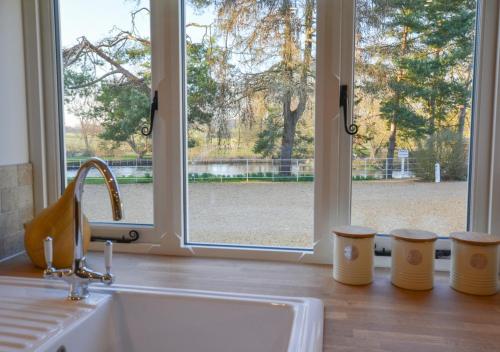 a kitchen counter with a sink and a window at Mill Cottage in Elsing