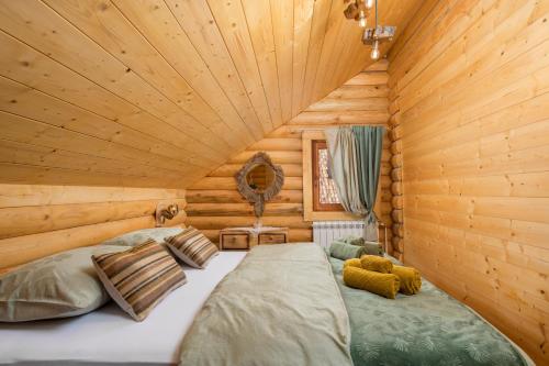 a bedroom with a bed in a log cabin at Kuća DORINE in Fužine