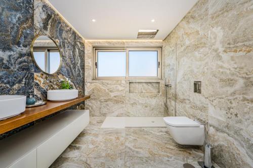 ein Badezimmer mit zwei Waschbecken und einer Toilette und einem Spiegel in der Unterkunft Lê Maison Deluxe Madeira - Where Peace is breathed and Luxury is felt! in Ponta do Sol