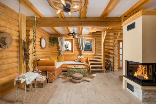 a living room with a fireplace in a log cabin at Kuća DORINE in Fužine