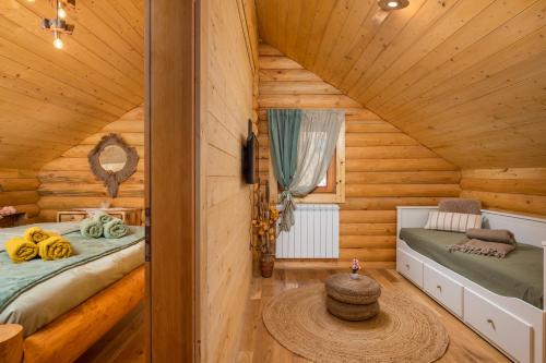 a bedroom with two beds in a log cabin at Kuća DORINE in Fužine