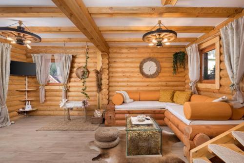 a living room with a couch in a log cabin at Kuća DORINE in Fužine