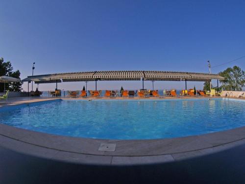 a large swimming pool with chairs and a pavilion at Mora Hotel in Trabzon
