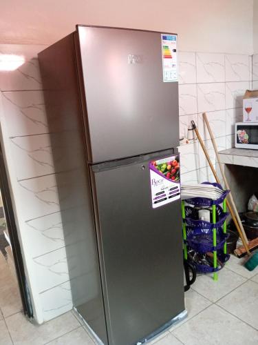 a stainless steel refrigerator in a kitchen at NEW VILLA TWO ROOMS KANOMBE in Kigali