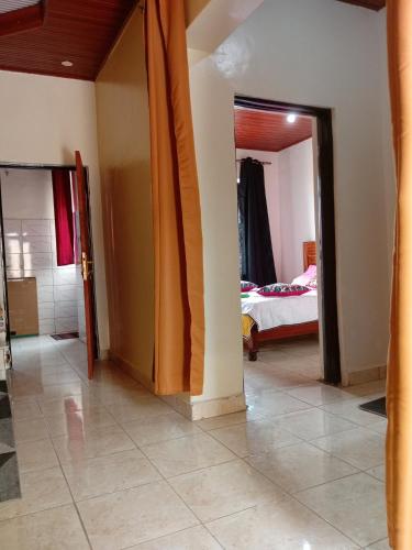 a hallway with a bedroom and a bed in a room at NEW VILLA TWO ROOMS KANOMBE in Kigali