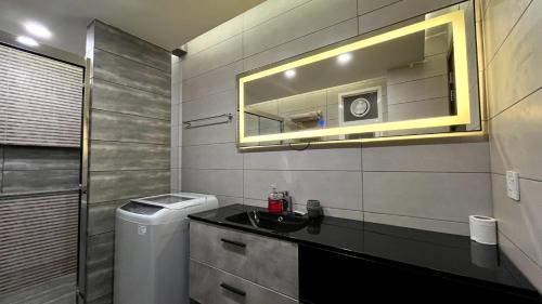 a bathroom with a sink and a mirror at City Escape with Mountain Views 1-Bed Apartment in Islamabad