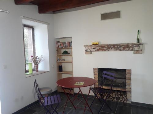 a table and chairs in a room with a fireplace at Chambre double in Vallon-en-Sully