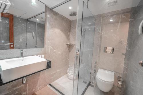 a bathroom with a sink and a toilet and a shower at Ramoji Film City- Tara Comfort Hotel in Pedda Ambarpet