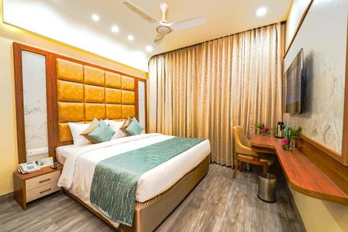 a hotel room with a bed and a desk and a desk at Ramoji Film City- Tara Comfort Hotel in Pedda Ambarpet