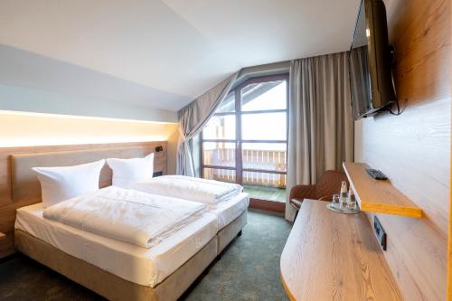 a hotel room with a bed and a window at Hotel Berghof in Petersberg