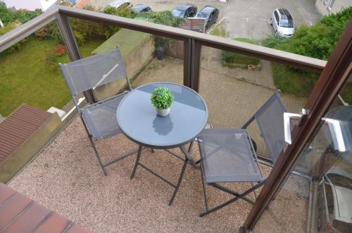 a table and chairs on a balcony with a potted plant at Hotel Zum Seemann in Cuxhaven