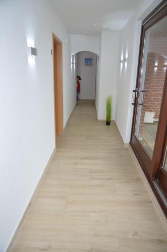 a hallway in an office building with a wooden floor at Hotel Zum Seemann in Cuxhaven