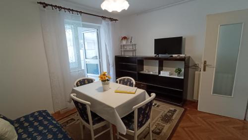 salon ze stołem, krzesłami i telewizorem w obiekcie Apartments Gabriela w Poreču