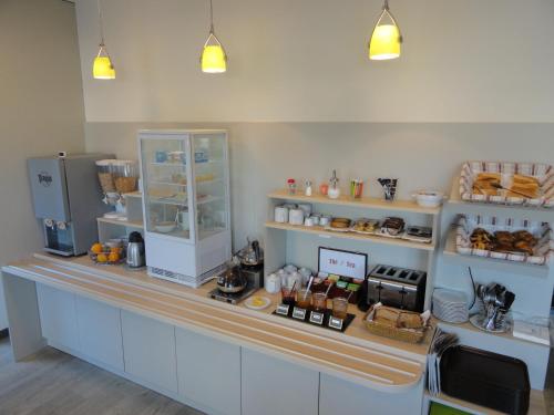 a kitchen with a counter with aasteryasteryasteryasteryasteryasteryasteryasteryastery at The Originals City, Hôtel Continental, Poitiers in Poitiers