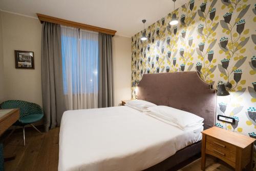 a bedroom with a large white bed and a window at Duca D'Aosta Hotel in Aosta