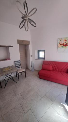 a living room with a red couch and a table at B&B Le Vie del Borgo in Castiglione di Sicilia