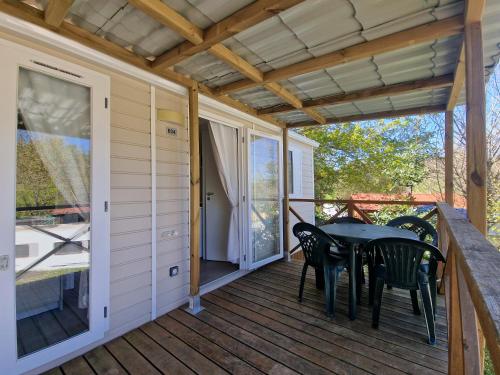 a screened porch with a table and chairs on it at Camping El Helguero in Ruiloba