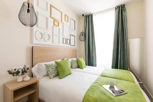 a bedroom with a large bed with green accents at Precioso apartamento a 2 minutos de El Retiro in Madrid