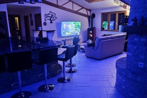 a living room with a couch and a table and chairs at Les Gîtes KARMA in Andres