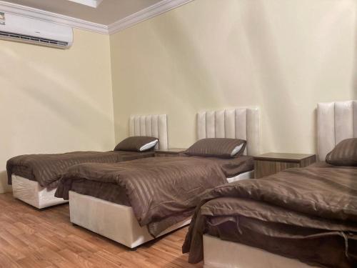 um quarto com três camas num quarto em Al-mohamdiah apartments em Meca