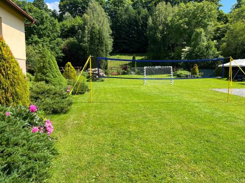 a lawn with a volleyball net in a yard at Willa Rubin in Kudowa-Zdrój