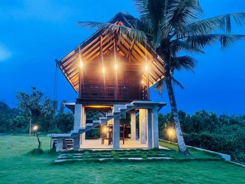 a house on an island with a palm tree at Ceylon Nature Paradise in Uragasmanhandiya