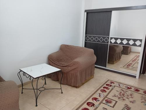 Soma Suites في المدينة المنورة: غرفة معيشة مع كرسي وطاولة