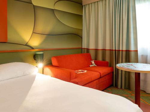 リジューにあるIbis Styles Lisieux Normandieのベッドルーム1室(ベッド1台、椅子、テーブル付)