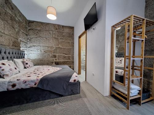 a bedroom with a bed and a wooden staircase at Villa Boas House in Castro Daire